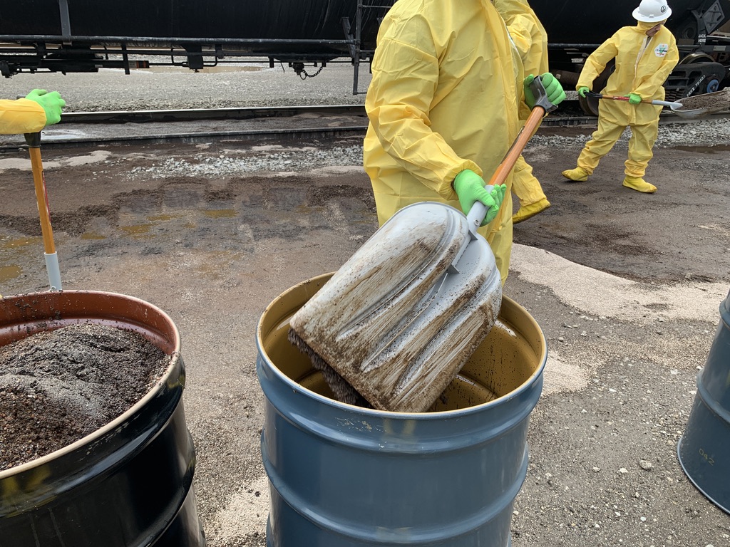 Scooping oil dry into drum by cleanup crew