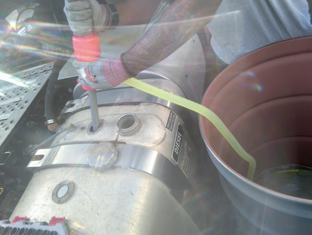 a siphon pump to pump out the remaining fuel from out the saddle tank to place into one of the staged drums.