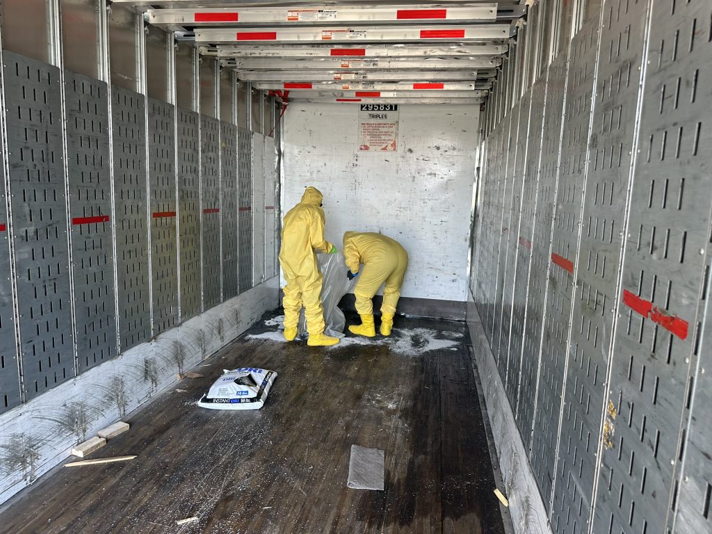 hazmat cleanup crew tackles a solvent spill in trailer. Chemical solvent spills can be cleaned up
